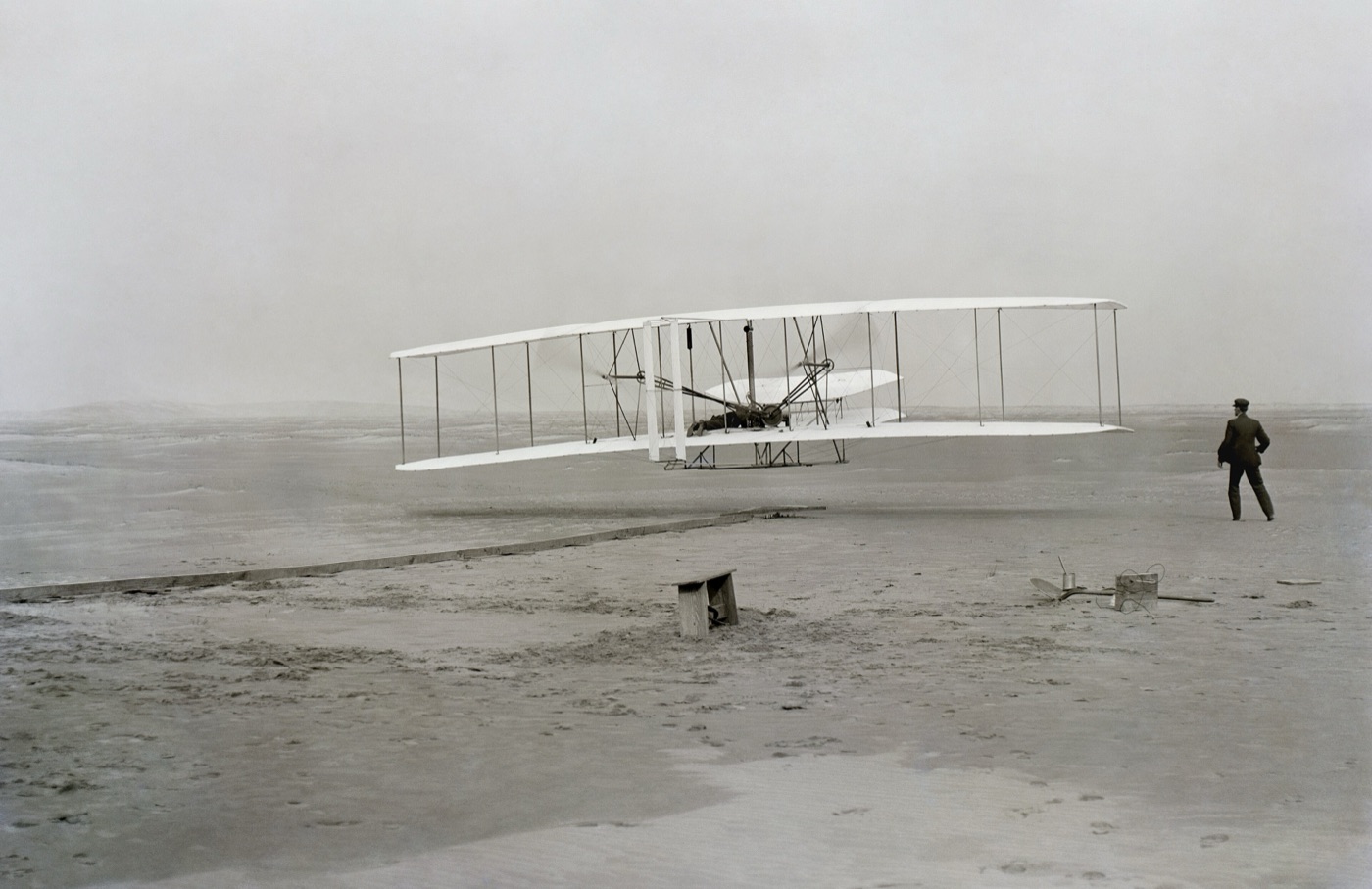 The Wright Flyer lifting off at Kitty Hawk in 1903, with Wilbur Wright running alongside